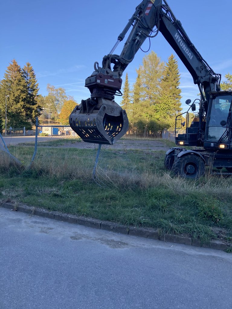 Bagger entfernt Zaun